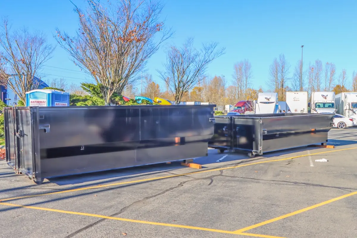 Professional dumpster rental service with roll-off container on residential driveway in West Pleasant View